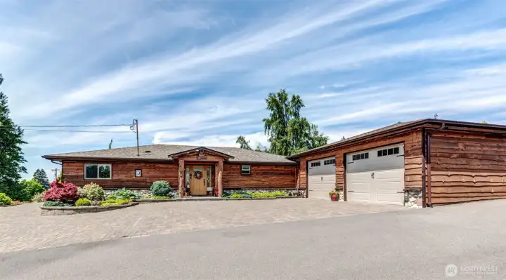 A striking first impression- custom wood craftsmanship, expansive parking, and timeless Northwest estate appeal.