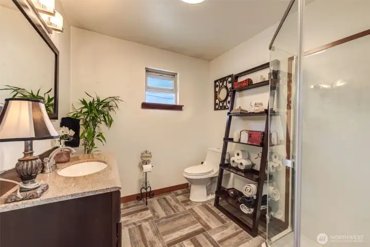 Updated guest bathroom featuring durable tile flooring and a glass shower enclosure.