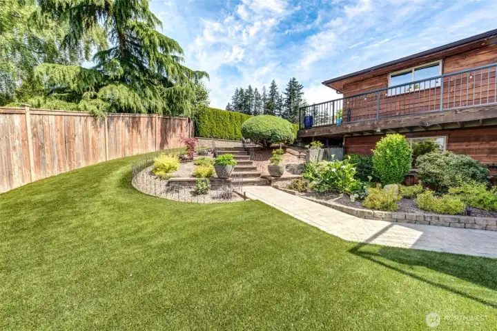 Terraced landscaping provides effortless flow between the upper outdoor living areas and expansive lower yard.