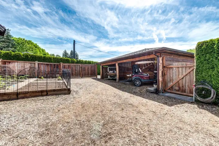 A gardener’s paradise featuring multiple garden areas, covered storage, and ample space for equipment and projects, conveniently located just off the garage.