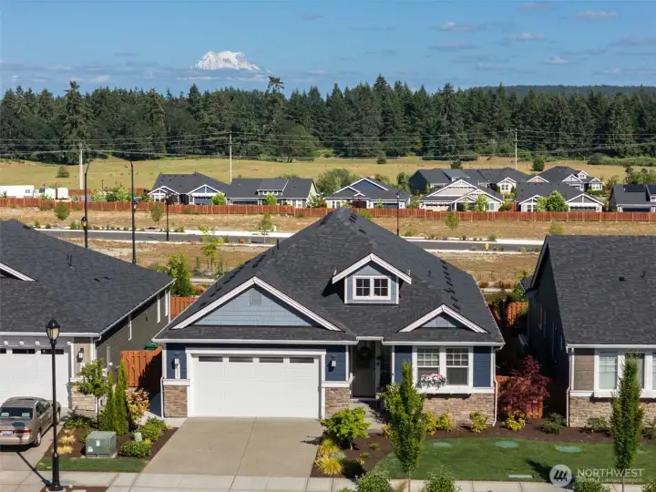 From above, you can see the welcoming streetscape of Ovation at Oak Tree, with Mount Rainier standing proudly in the distance as a reminder that you're living in one of the most beautiful regions in the country. Miles of flat sidewalks weave throughout the community, creating the perfect setting for daily walks, bike rides or catching up with neighbors along the way. When it's time to run errands, meet friends for lunch or stock up at Costco, the Hawks Prairie shopping district is only minutes away. It's the kind of location that makes everyday life feel wonderfully easy while still surrounding you with everything people love about the Pacific Northwest.