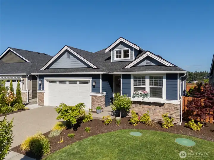 From above, you can appreciate the attractive curb appeal, charming flower-box-style window ledge beneath the front bedroom window and the beautifully manicured front yard that the HOA takes care of for you. No lawnmower required. No Saturday afternoons spent pulling weeds. Even the backyard embraces an easy-care approach with attractive low-maintenance landscaping and hardscaping instead of grass to constantly maintain. The two green circles visible in the front yard are components of the home's STEP sewer system. Here, your weekends are freed up for pickleball matches, pool time, fitness classes, social events or simply enjoying everything Ovation at Oak Tree has to offer instead of tackling an endless to-do list outdoors.