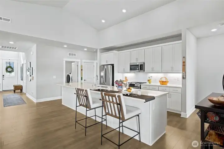 Standing in the kitchen, you can see how the home naturally branches into distinct living zones without ever feeling chopped up or compartmentalized. The laundry room sits just steps away for everyday convenience, while the adjacent den or potential third bedroom creates a flexible space that can evolve with your needs. Tucked away down its own private alcove, the primary suite enjoys welcome separation from guests and visitors, giving homeowners a quiet retreat at the end of the day. It's smart design wrapped in beautiful finishes.