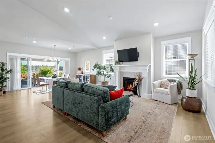 The soaring vaulted ceiling adds volume and light, while the open connection between the living room and dining area creates the kind of easy flow buyers are always looking for. A dramatic wall of windows and sliding glass doors stretches across the back of the home, bringing the Mt. Rainier vista along with the beautifully landscaped backyard and covered patio into view and making the entire space feel even larger. When guests arrive, the party naturally spills outside onto the covered patio.