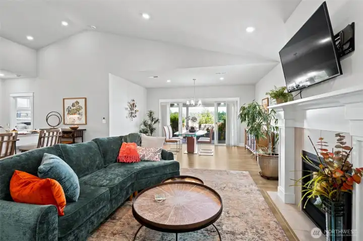 Some open floorplans look great on paper but feel cramped once the furniture arrives. Not this one. This perspective showcases the impressive scale of the main living areas and how easily the kitchen, dining and living spaces work together without stepping on each other's toes. The soaring vaulted ceilings add even more volume, while the oversized island creates a natural gathering place between the rooms. Whether your style leans toward hosting big family celebrations, intimate dinner parties or simply spreading out and enjoying everyday life, this floorplan gives you options. Add the beautiful Mt. Rainier views stretching across the rear of the home, and you've got a living space that feels spacious, welcoming and ready for whatever the next chapter brings.