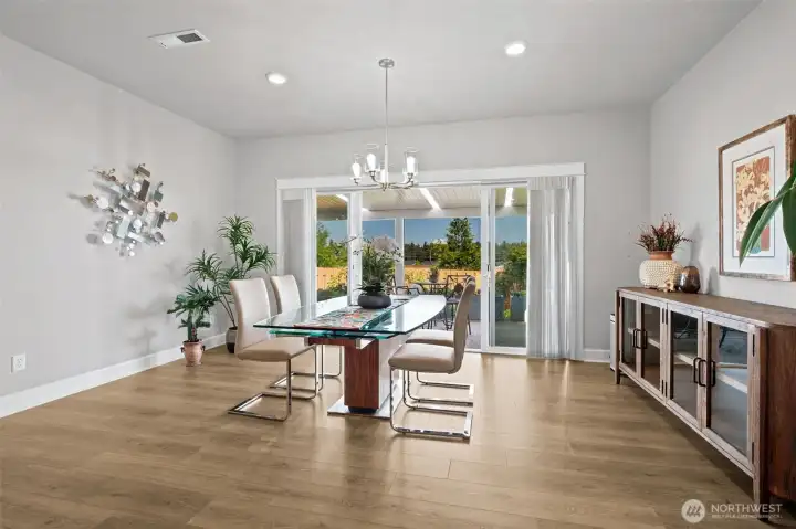 Dinner comes with a view here. This generously sized dining area offers the flexibility to host everything from intimate weeknight meals to larger holiday celebrations without feeling crowded. The sleek brushed nickel chandelier brings just the right amount of contemporary style, while the clean lines and neutral palette allow the mountain views to remain the star of the show. There's ample space for a larger table if desired, plus room for a buffet or serving piece along the wall to complete the look. Recessed lighting adds another layer of illumination, and every glance toward the window rewards you with a postcard-worthy Mount Rainier view that turns even an ordinary Tuesday dinner into something special.
