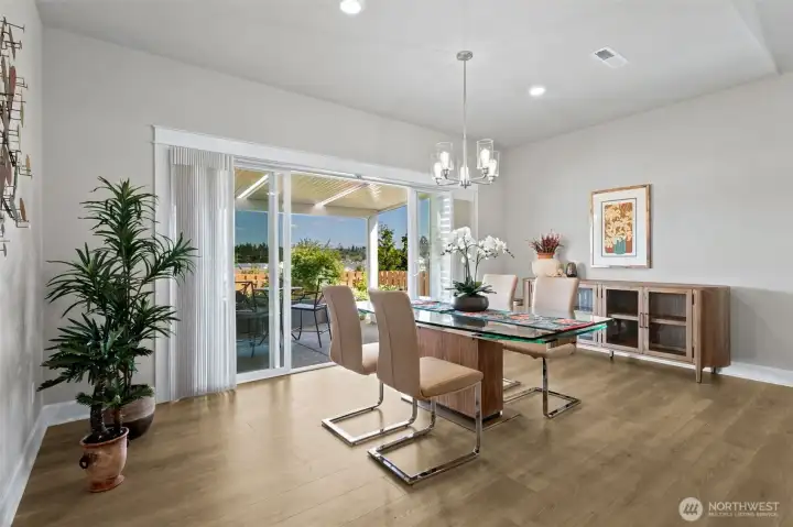 One of the smartest features in this home is hiding in plain sight. This isn't a standard slider—it's a wide double sliding glass door that dramatically expands the connection between the dining room and the covered outdoor living area. On beautiful days, opening both sections creates an airy, open feel that blurs the line between indoors and out. Friends can easily move between spaces during gatherings, and everyday meals come with a front-row seat to the covered patio and stunning Mount Rainier views beyond. It's the kind of thoughtful design feature that makes the home live larger than its square footage and turns the patio into a true second living room. And if you've ever worried that a dining room might be too small for Thanksgiving, Christmas or your annual wine-and-charcuterie gathering, this room is here to calm those fears. The generous proportions easily accommodate a larger dining table for big celebrations while maintaining comfortable circulation throughout the space.