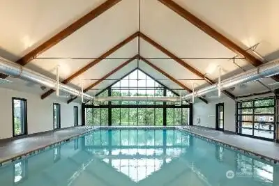 Some communities have a pool. Ovation at Oak Tree has a destination. Wrapped in walls of glass and surrounded by towering oaks, this impressive aquatic center combines resort-style comfort with everyday convenience. The vaulted wood-beam ceiling adds warmth and character, while large roll-up doors can be opened during beautiful weather to let the fresh air flow through the space. Whether you're swimming laps, unwinding after a workout or simply enjoying the view, this amenity sets the tone for the lifestyle offered here. Add in the sauna, locker rooms, fitness center, yoga classes, tennis, pickleball and an active social calendar, and suddenly retirement starts looking suspiciously like a permanent vacation.