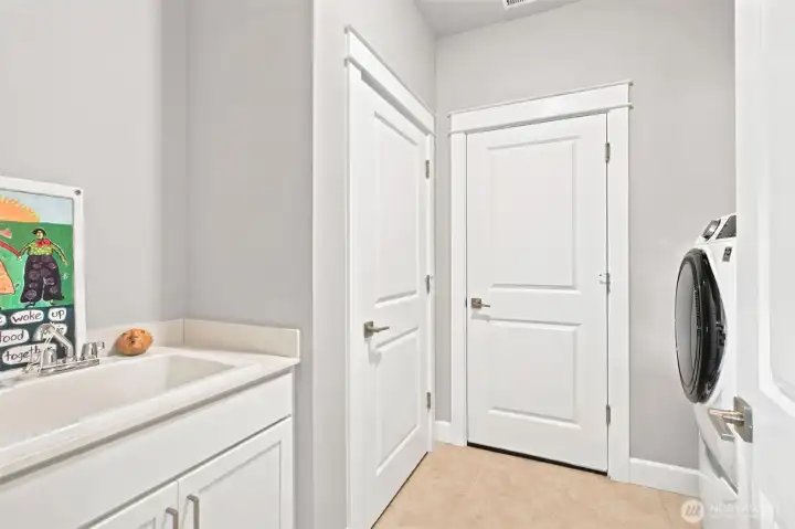 Conveniently located just inside the garage entry, this laundry room is perfectly positioned as a transition zone between the outdoors and the heart of the home. The utility sink is ideal for everything from soaking gardening gloves to filling a mop bucket, while a deep storage closet provides valuable space for cleaning supplies, seasonal items or household essentials. There's plenty of room for a full-size high-efficiency washer and dryer setup, making laundry day a little less of a chore.