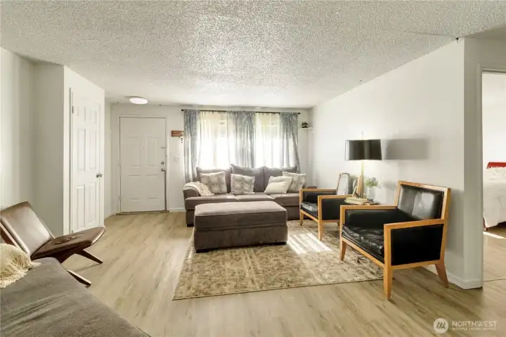 Unit A living room featuring updated flooring and abundant natural light.