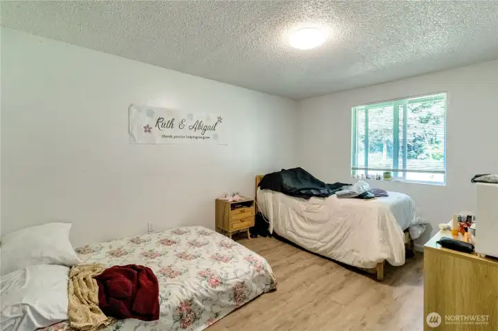 Unit A second bedroom with window overlooking the backyard.