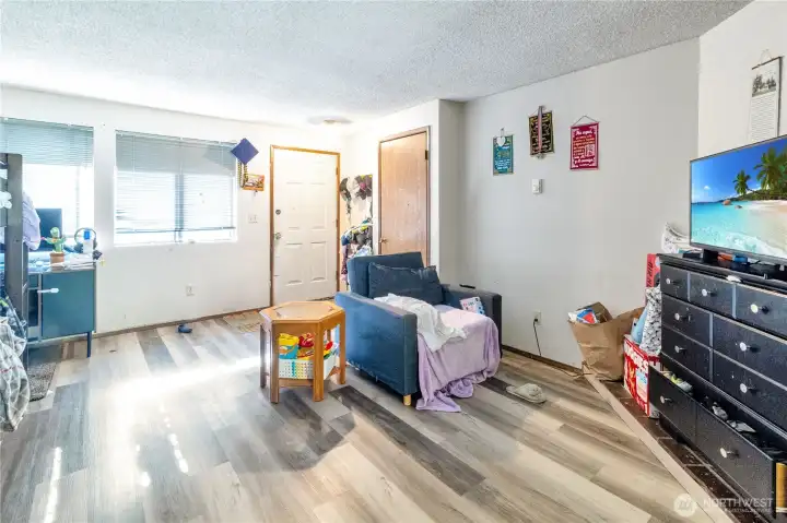 Unit B living room with updated flooring and open flow to the kitchen.