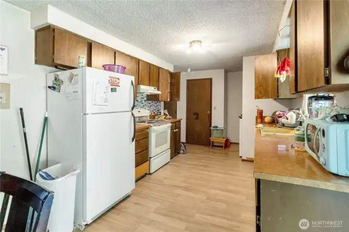 Unit B kitchen with abundant cabinetry and dining area.