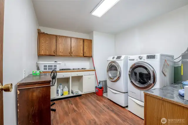 Large utility room with cabinets, washer and dryer stay with home
