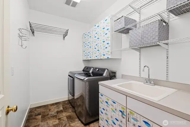 Main level laundry room with sink and drying rack.