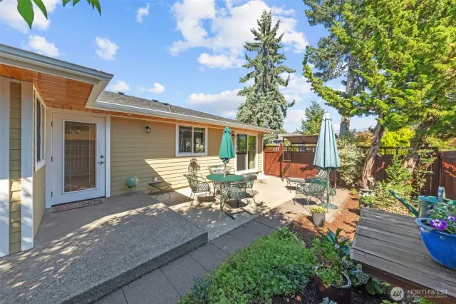 Adorable side yard with patio and gardens