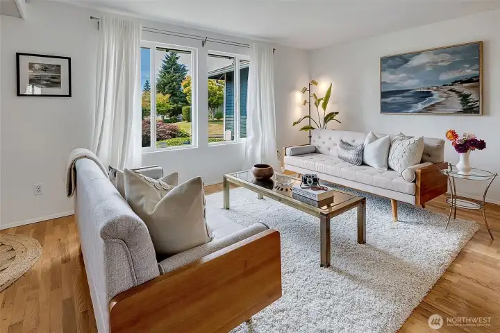 Abundant natural light, updated windows, and original oak hardwood floors in the spacious living room with