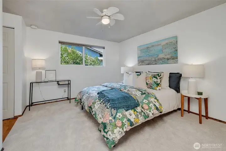 Spacious primary bedroom with new carpet and paint. The ceiling fan adds to the comfort on warm days.