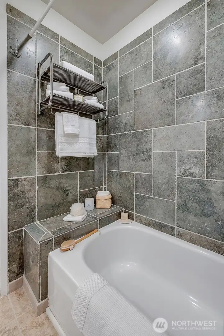 Deep tub with tiled surround in the main full bath.
