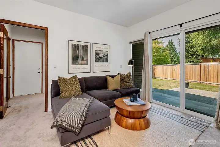 Family room with slider out to the BBQ patio & fully fenced back yard. Access to the laundry room & ¾ bath through the glass door (currently open), and the  2-car garage with extra storage racks and fridge is through the door on the left.