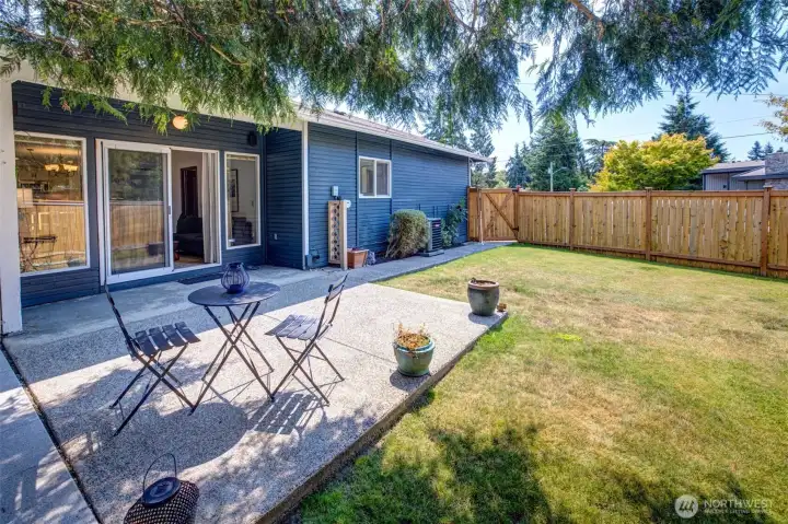 The west part of the backyard and patio off the family room. Newer fence with a gate leading to the driveway.