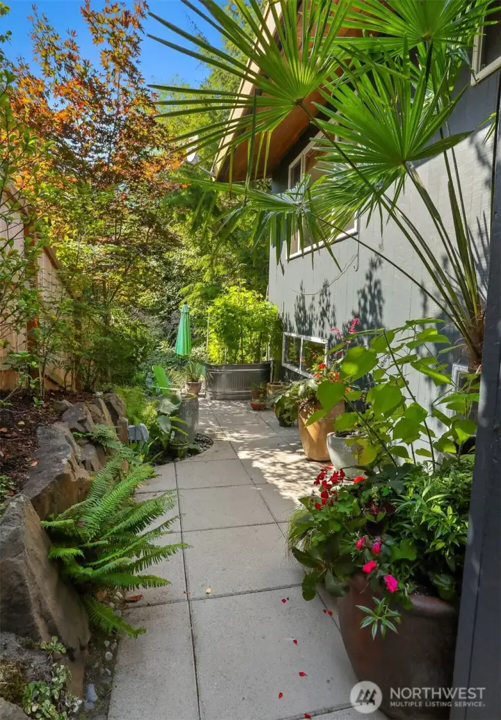 A meandering landscaped path ushers you along the professionally designed south side of the lot.