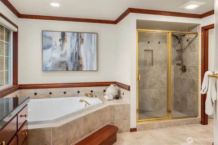 The primary shower, with tile surround, features shower niches.
