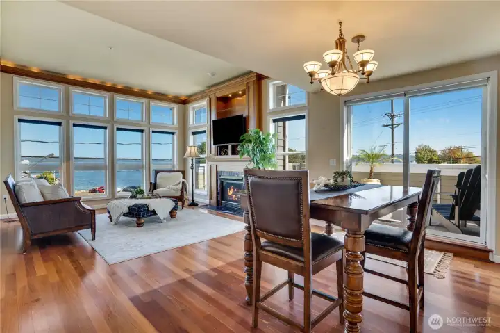 Step inside to a spacious open floor plan where rich cherry hardwood floors and walls of windows create a warm and inviting atmosphere.