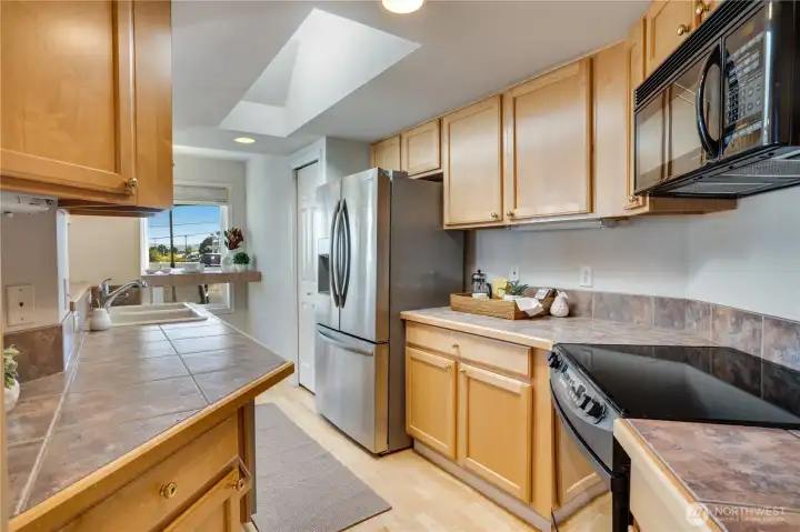 Generous counter space and a bright skylight make this kitchen a joy to cook in. A pantry just beyond the fridge adds even more storage.