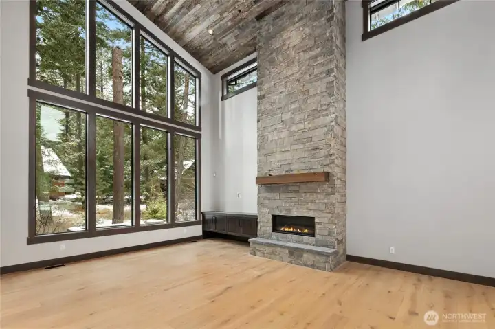 Soaring Great Room with tall windows and stone gas fireplace