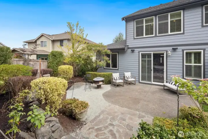 Gorgeous backyard with mature landscape, flagstone rock and concrete patio.  Standing fire pit and pond!