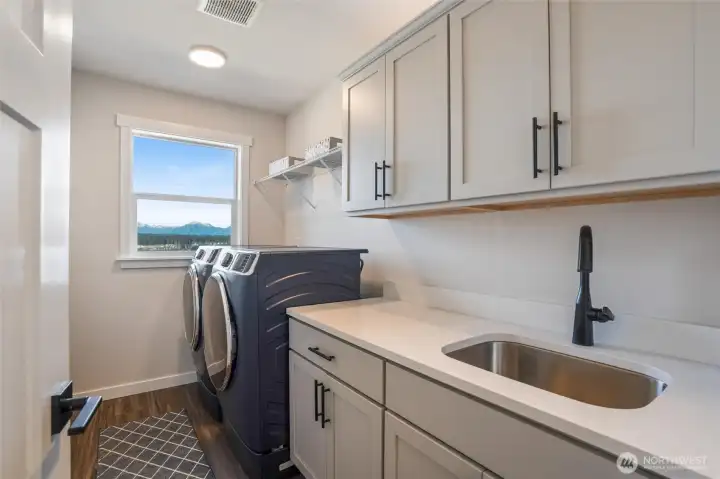 Upstairs laundry with mud sink,cabinetry and mountain view