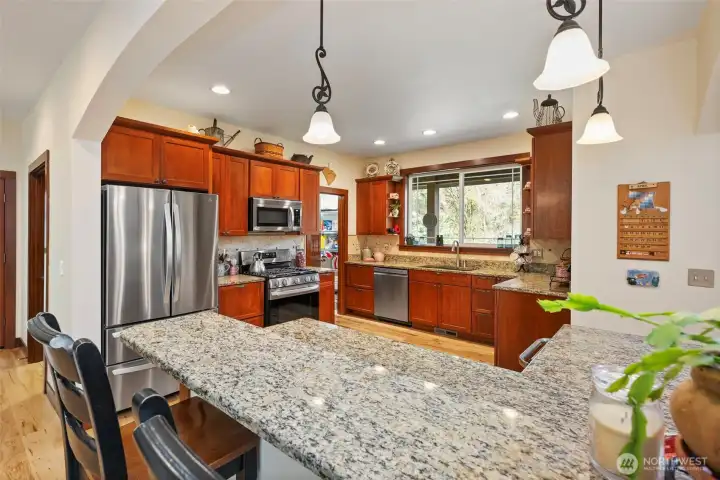 Kitchen with gleaming stainless appliances, granite countertops, a walk in pantry and beverage fridge.