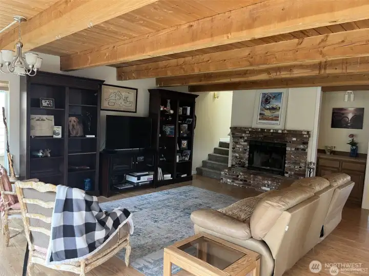 Here is the living room with furniture. Look at the brick wood burning fireplace. Also bar area and stairs leading to the second floor.