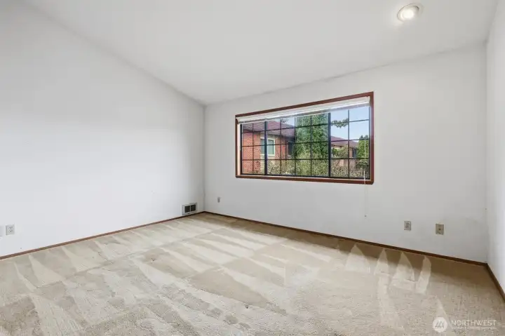 Large primary bedroom with vaulted ceiling.