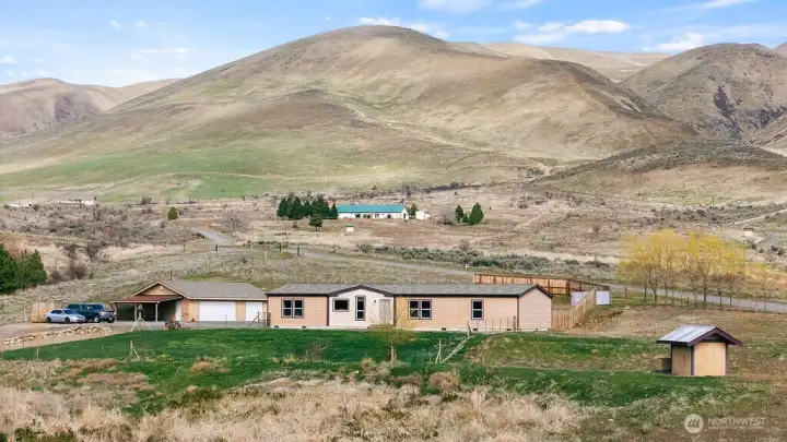 Full property view set against the rolling hills of Wenas Valley, showcasing the home, shop, and usable acreage all in one clean, open setting.