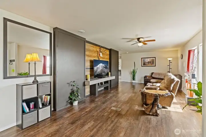 Expansive living room with updated flooring and a feature wall that creates a natural focal point for media or gathering space.