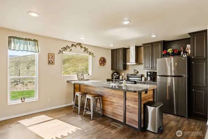 Functional kitchen with a large center island, bar seating, and ample prep space—ideal for cooking, gathering, and casual dining.