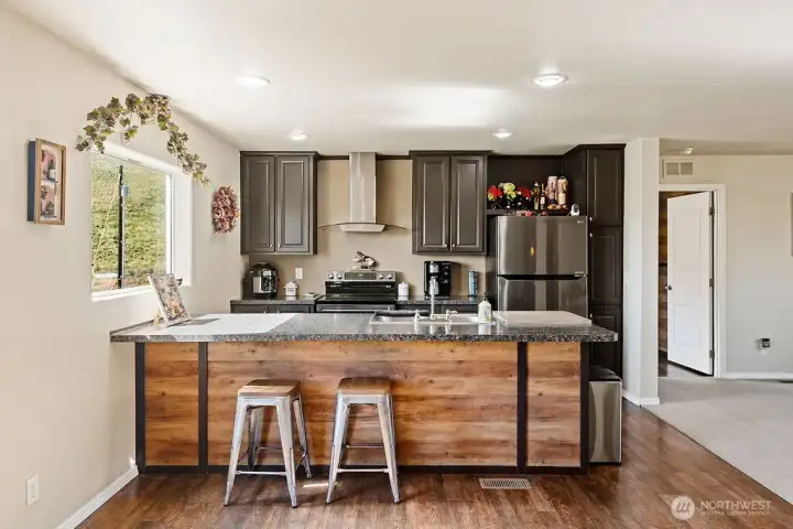 Full kitchen view showcasing the combination of storage, counter space, and island seating in a practical, user-friendly layout.