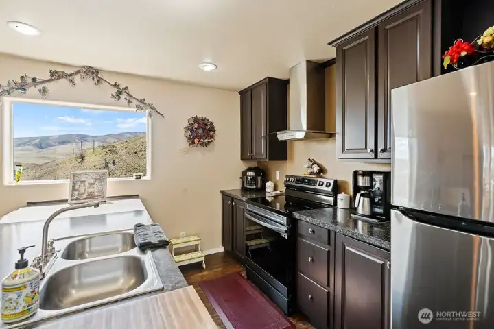 Well-appointed kitchen with stainless appliances, generous cabinetry, and a window perfectly positioned to take in scenic valley views.