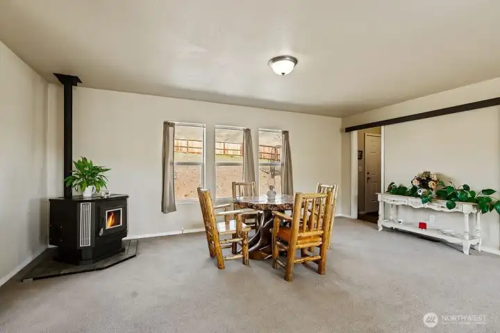 Cozy dining space featuring a pellet stove for warmth and ambiance, with natural light and views of the surrounding landscape.