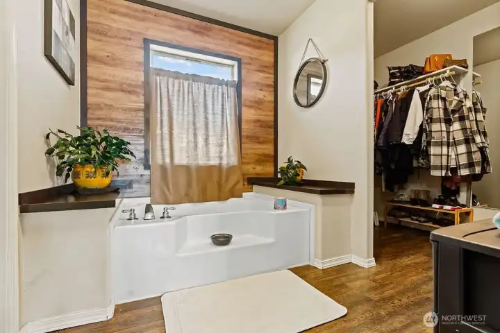 Relaxing soaking tub paired with nearby walk-in closet, offering a true primary suite setup with space and practicality.