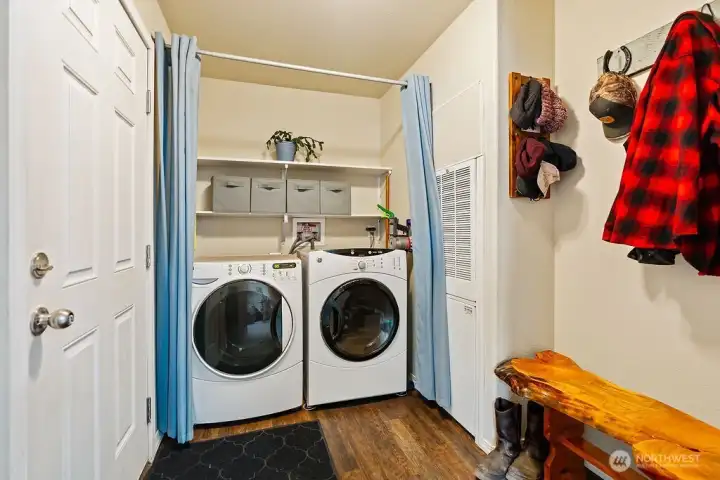 Dedicated laundry area with storage shelving and space for full-size washer and dryer—functional and conveniently located.