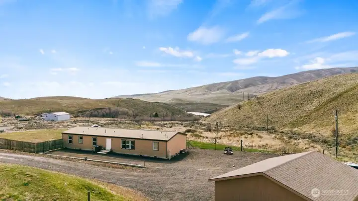 Rear aerial showcasing outdoor living space, including the fire pit area, fenced sections, and functional yard layout.