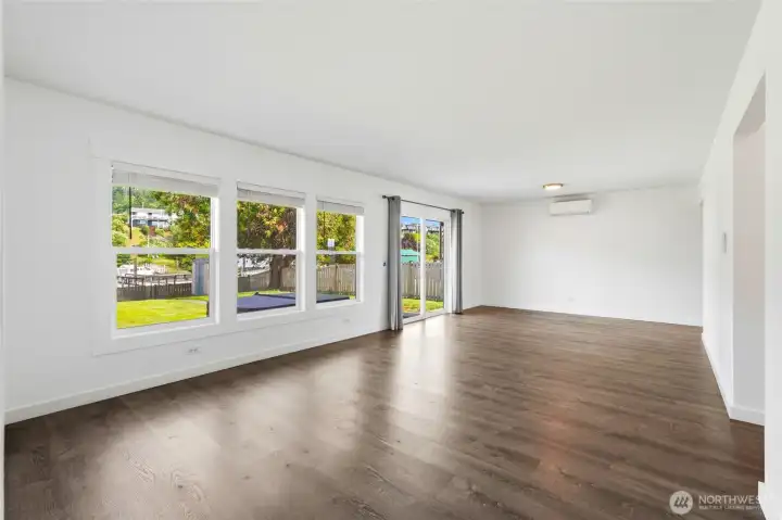 Living room with backyard views, sliding glass door access, and a mini-split for heating and cooling. Living room with backyard views, sliding glass door access, and a mini-split for heating and cooling.