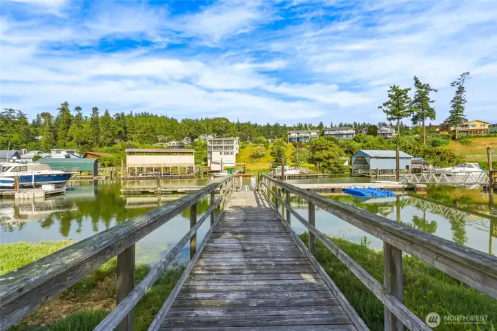 View down the private dock toward the marina, with boathouses and waterfront homes along the shoreline. View down the private dock toward the marina, with boathouses and waterfront homes along the shoreline.
