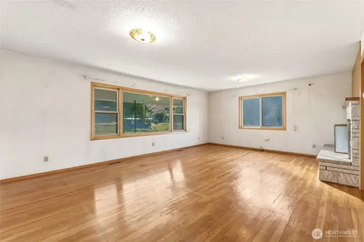 Living Room with Wood Burning Fireplace and Wood Floors