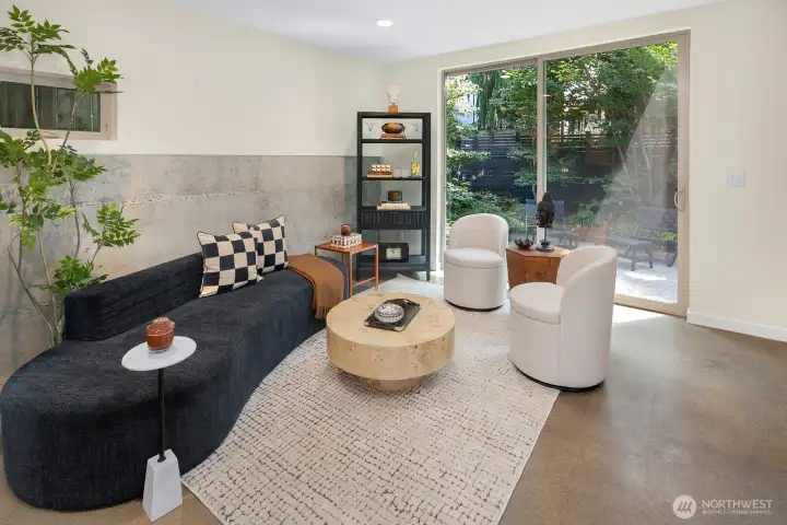 The living area extends effortlessly outdoors, creating an ideal setting for entertaining or enjoying a quiet afternoon surrounded by greenery.