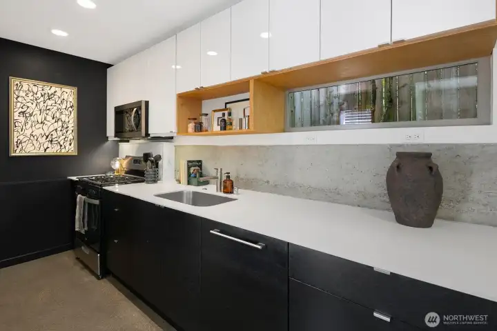 Concrete, quartz, and custom millwork give the kitchen a refined, gallery-like feel.