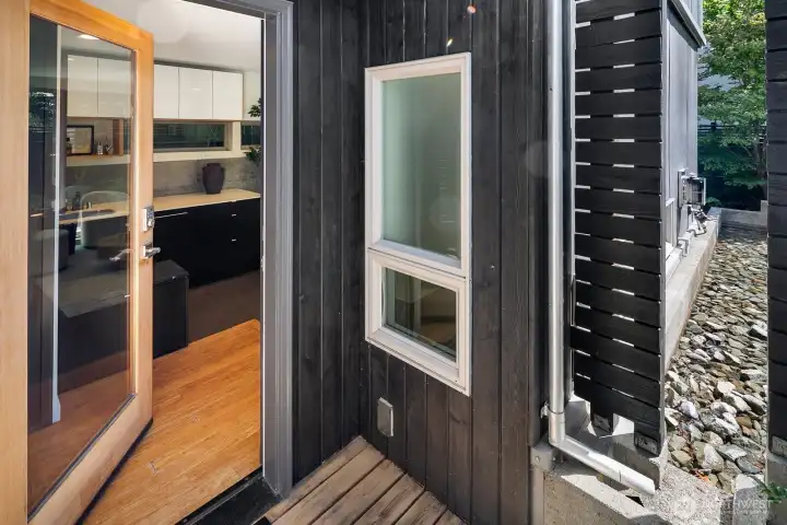 The design begins at the front door, with warm wood and clean modern detailing.
